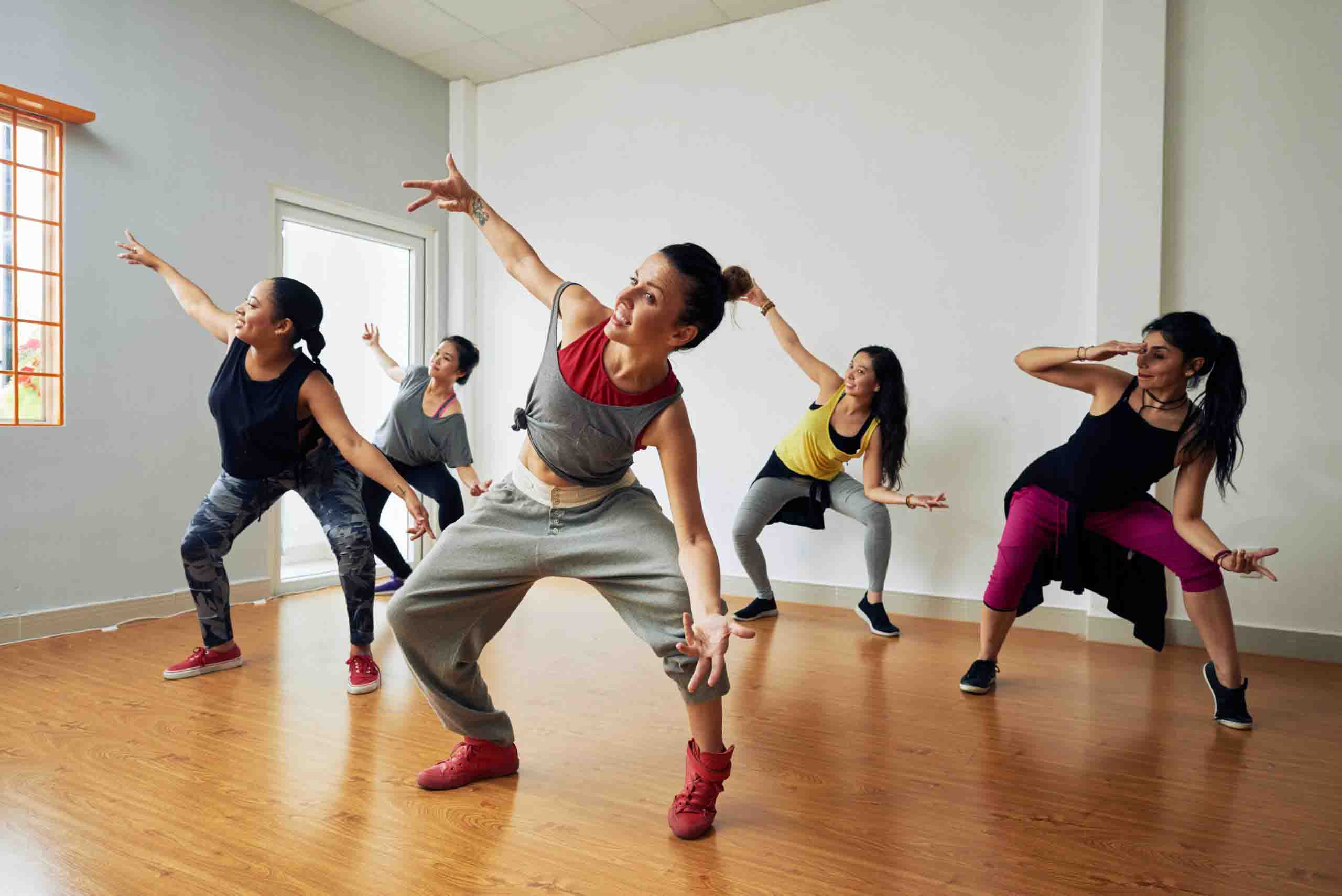 Een groep vrouwen die aan het dansen is in een sportzaal